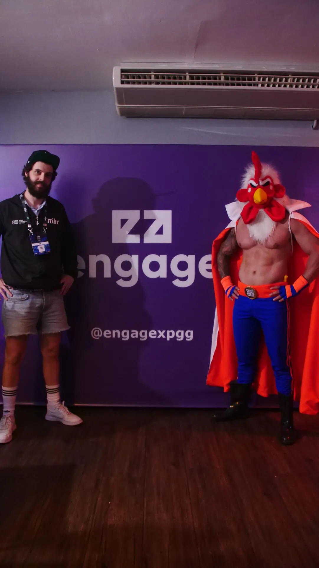 Chicken-man mascot at the EngageXP backdrop during IEM